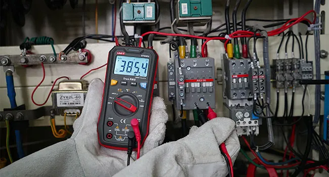 Electrician testing an industrial control panel